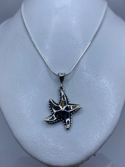 Estrella de mar granulada de plata .950 sobre cuello blanco, tamaño real de 4 centímetros