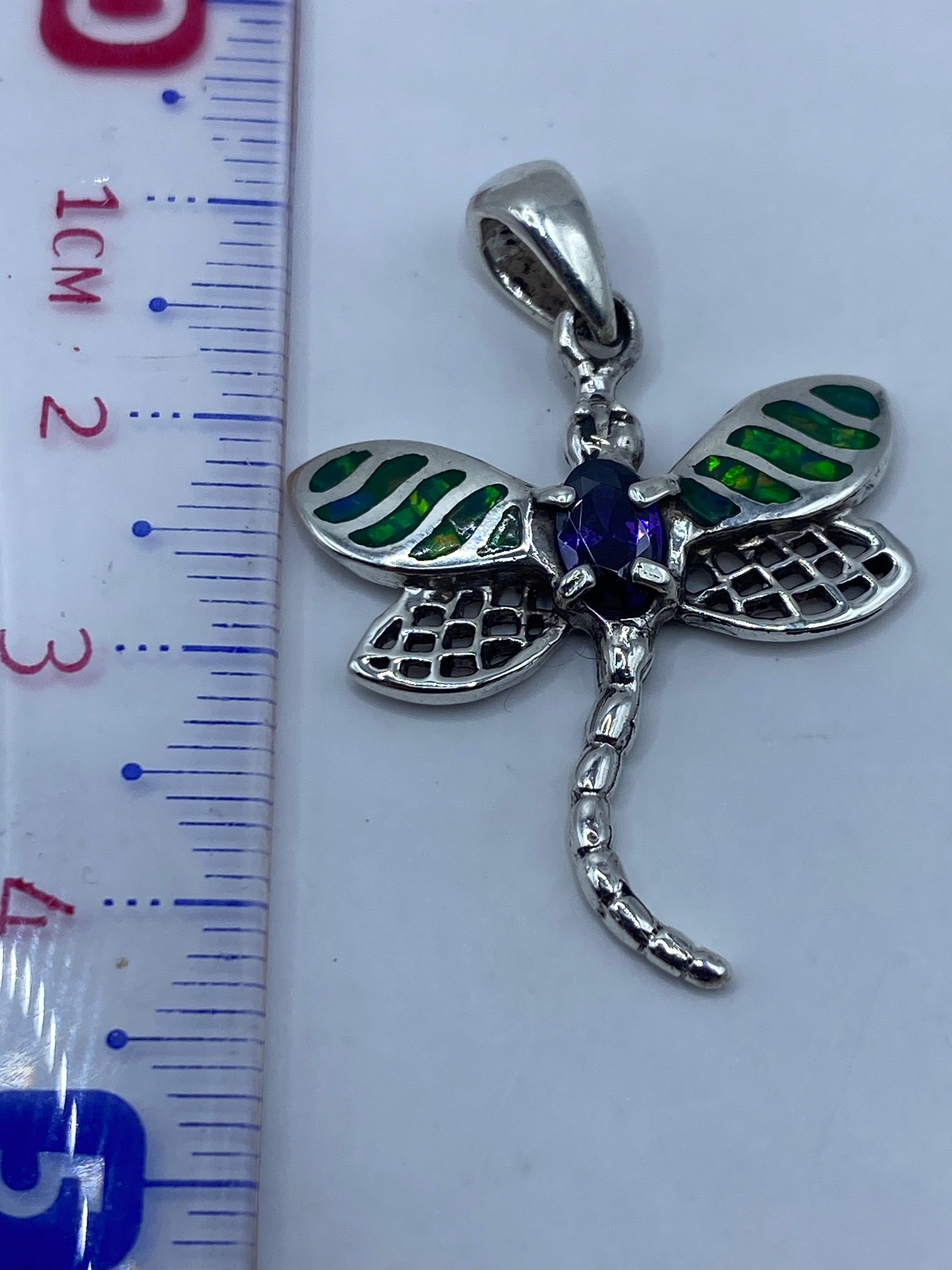 Dije libélula con regla de medida mostrando 4.3 cm de largo