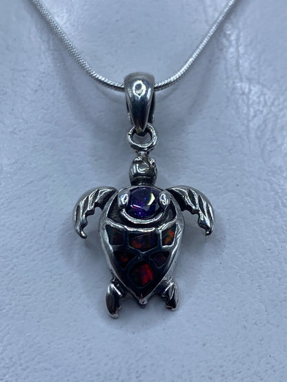 Dije tortuga de plata .925 con ópalo de fuego multicolor colgando de cadena de plata
