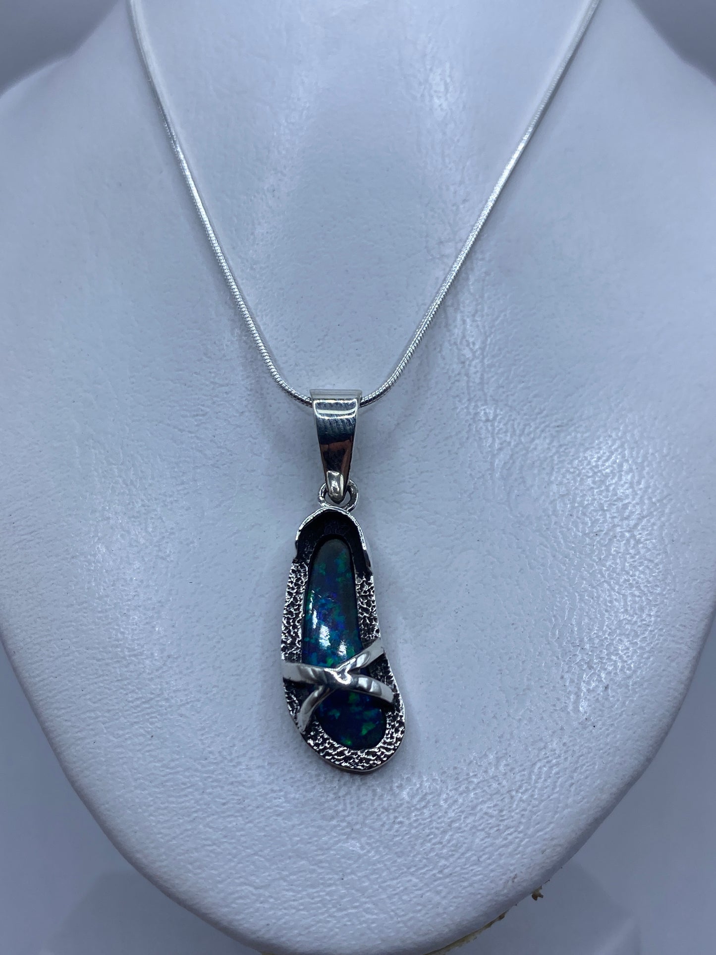 Detalle cercano del ópalo de fuego azul incrustado en plata, mostrando brillo y color