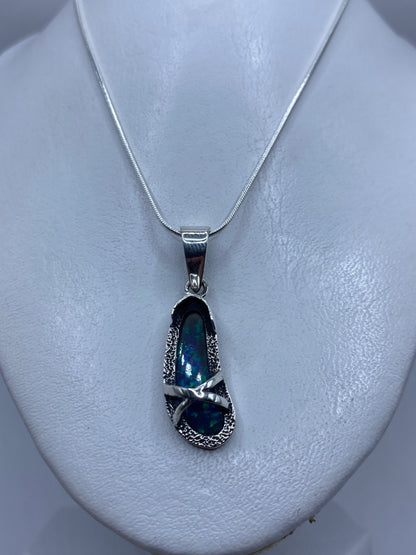 Detalle cercano del ópalo de fuego azul incrustado en plata, mostrando brillo y color