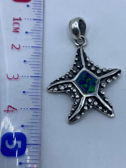 Detalle de la incrustación a mano del ópalo azul en la estrella de plata