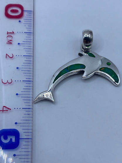 El dije de 4.1 cm junto a una regla de centímetros, mostrando su tamaño real