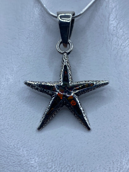 Dije estrella de mar en plata .950 con ópalo de fuego multicolor colgado de cadena plateada