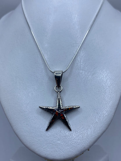 Ópalo de fuego multicolor en tonos naranja, verde y violeta engastado en la estrella
