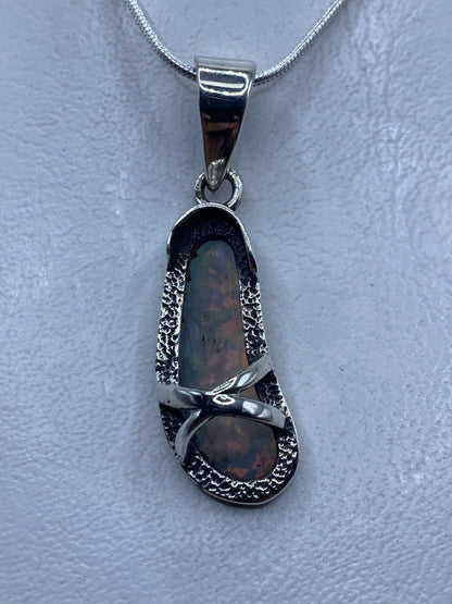 Dije de plata .925 con ópalo de fuego engastado, colgando de una cadena plateada