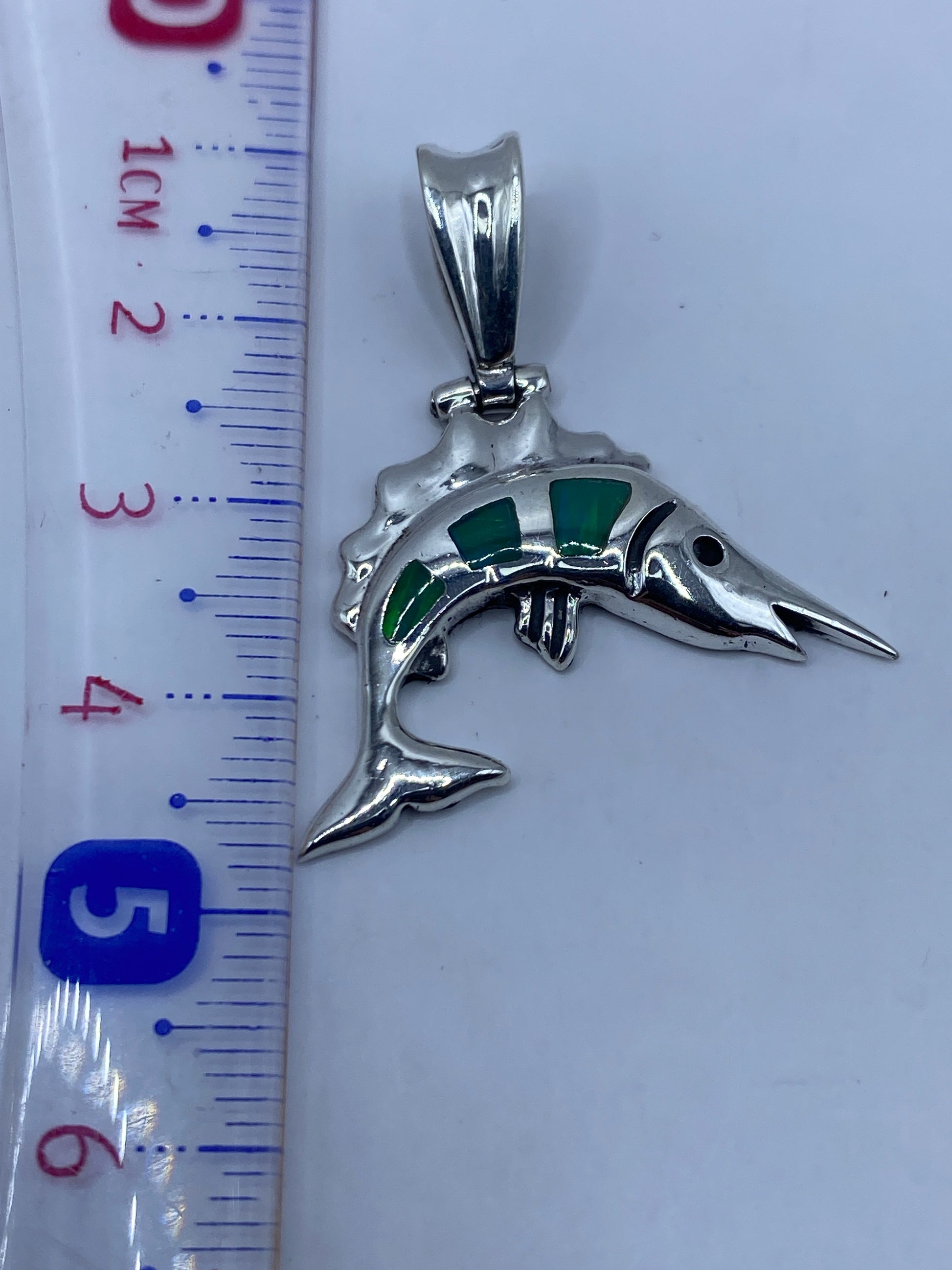 Medición del dije en escala: 4.2 cm de largo · Peso 4.8 gramos