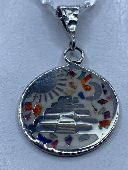 Dije de plata con ópalo de fuego multicolor colgando de una cadena delgada