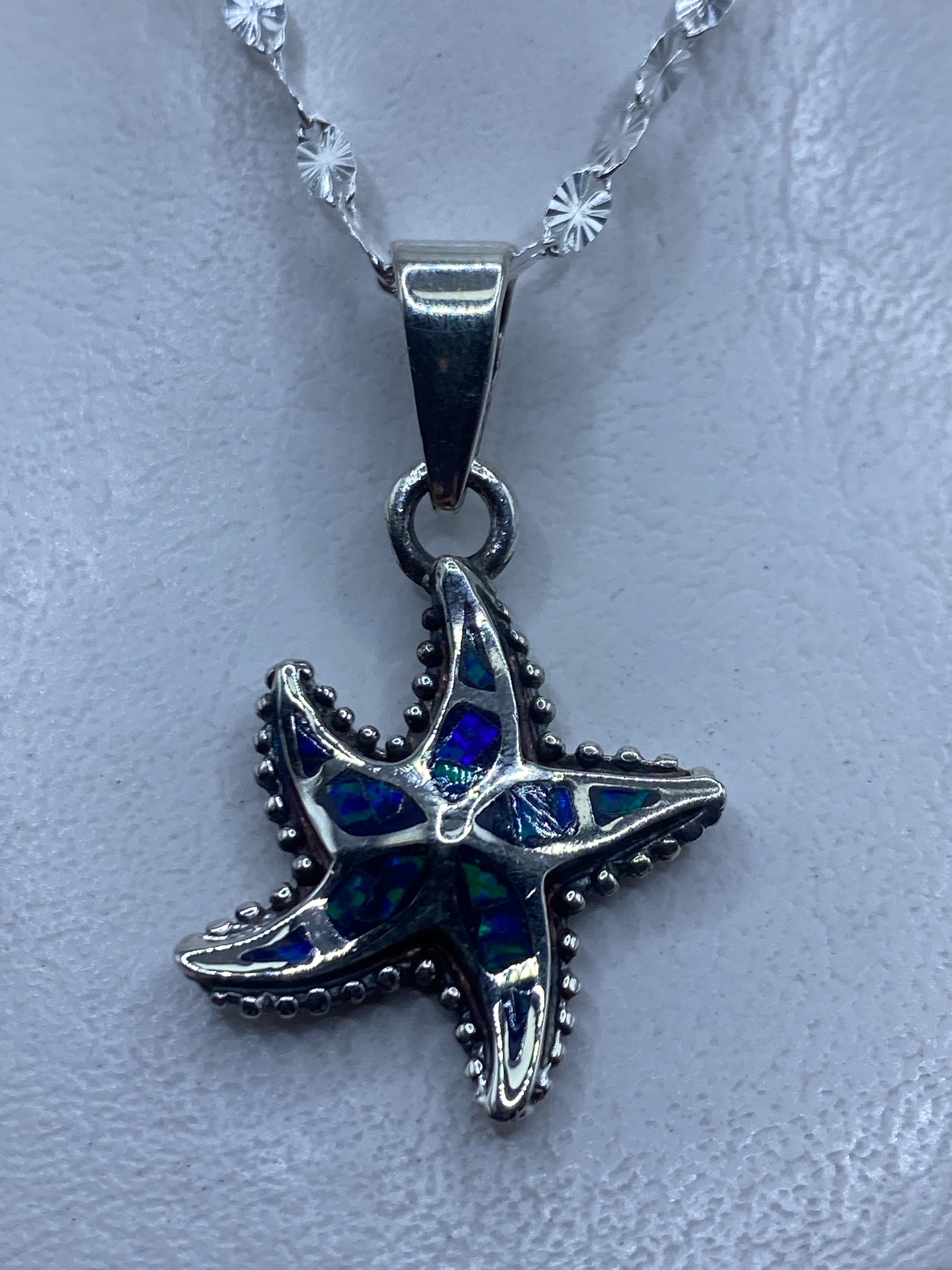 Dije de estrella marina en plata .950 con ópalo de fuego azul engastado a mano, colgando de cadena ornamental
