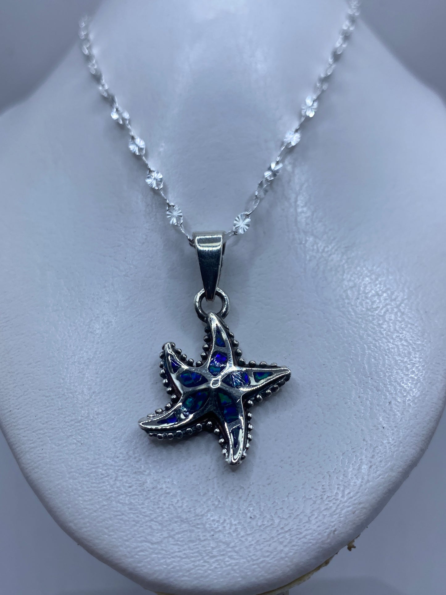 Detalle de la estrella marina mostrando los pétalos granulados y el ópalo azul en el centro