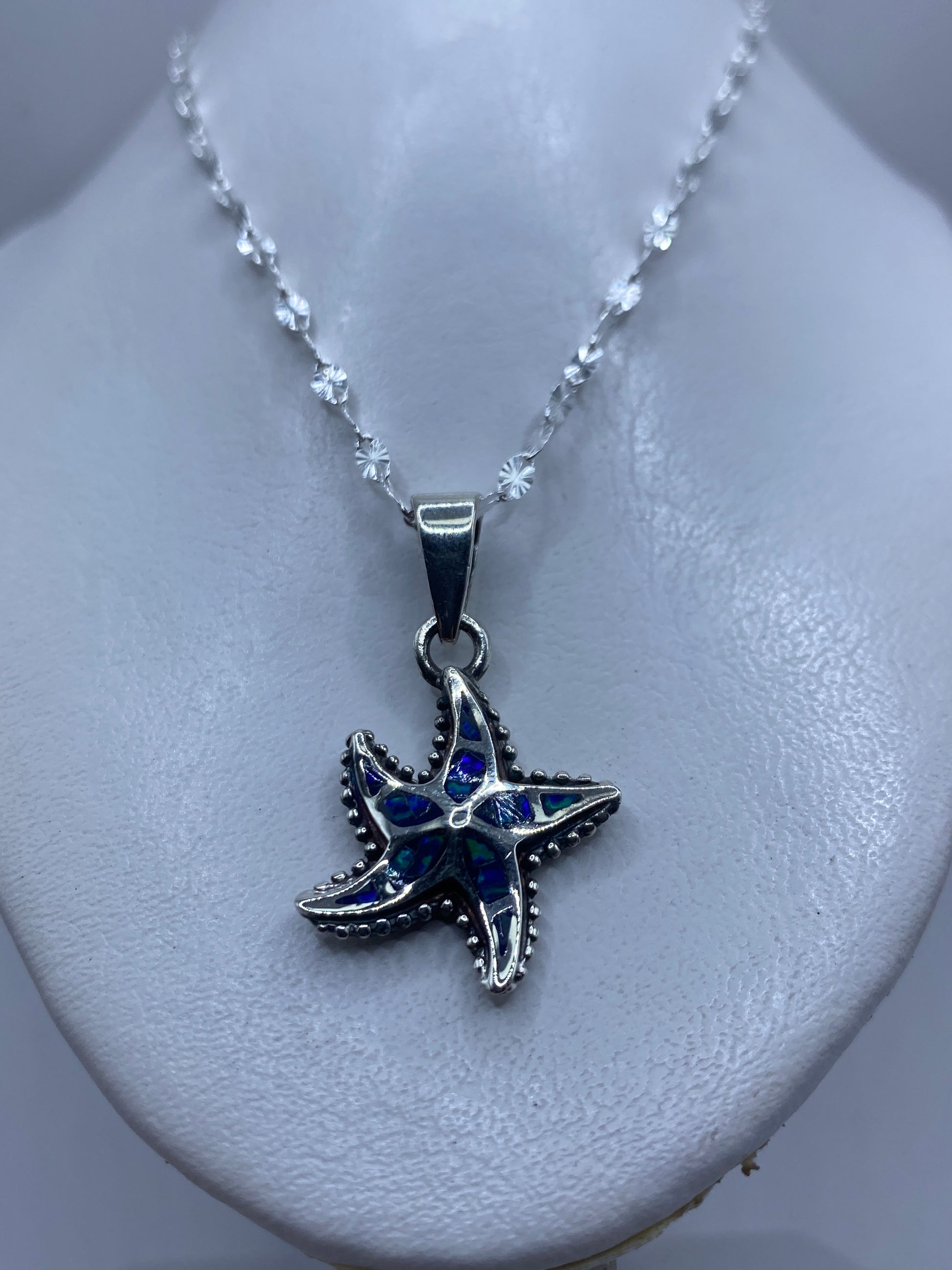 Detalle de la estrella marina mostrando los pétalos granulados y el ópalo azul en el centro