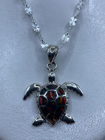 Dije de tortuga marina en plata .950 con ópalo de fuego multicolor engastado, colgado de cadena con beads de plata
