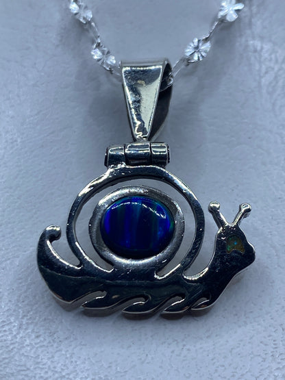Dije caracol de plata .950 con ópalo de fuego azul, engastado a mano en Taxco