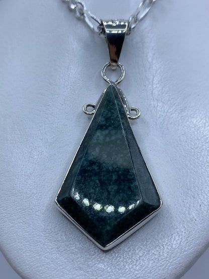 Dije de plata .950 con piedra verde incrustada, forma geométrica alargada, sobre cadena de plata