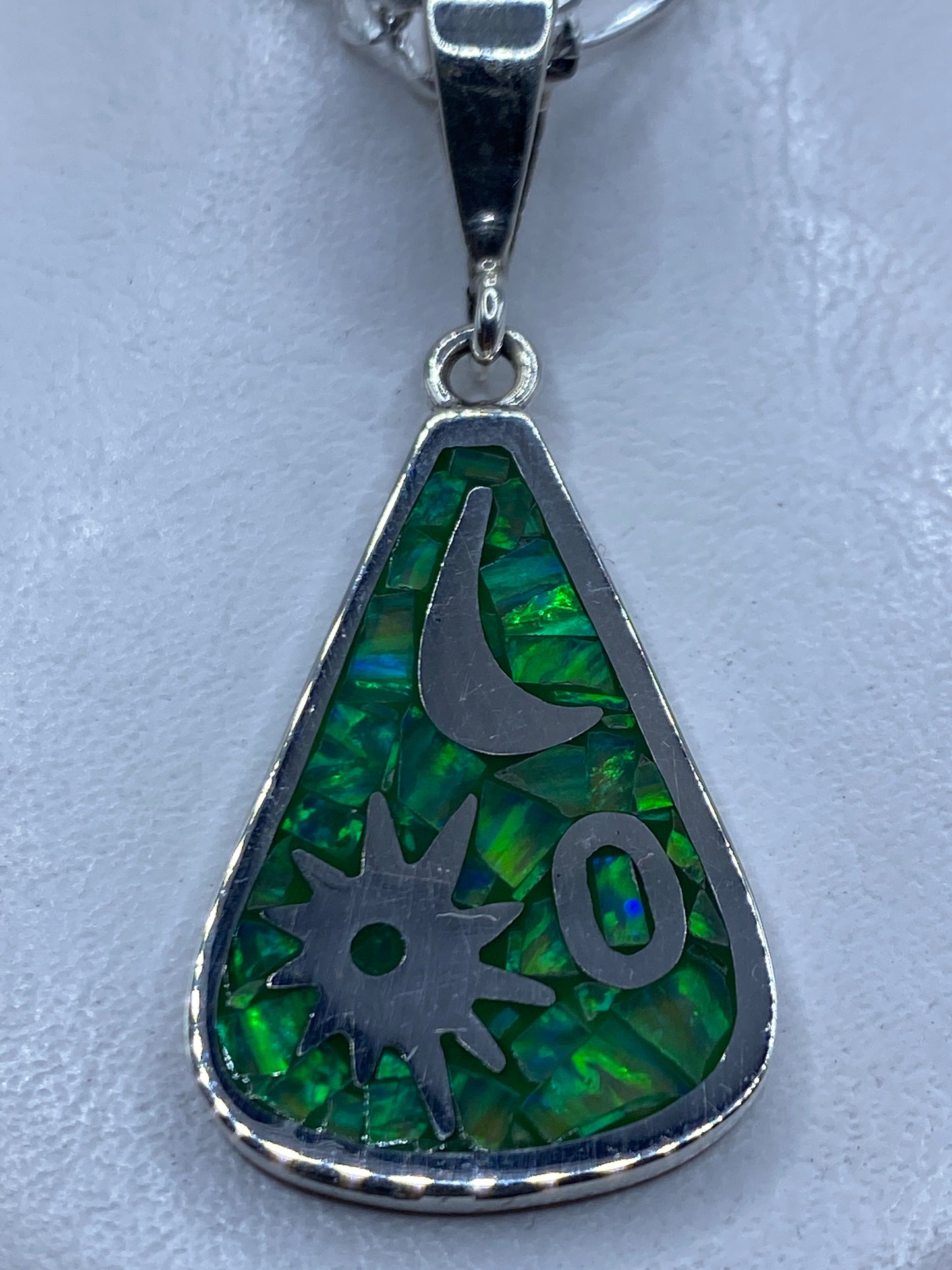 Dije de plata con ópalo de fuego verde limón y símbolos Luna y Medicina, colgado de una cadena plateada