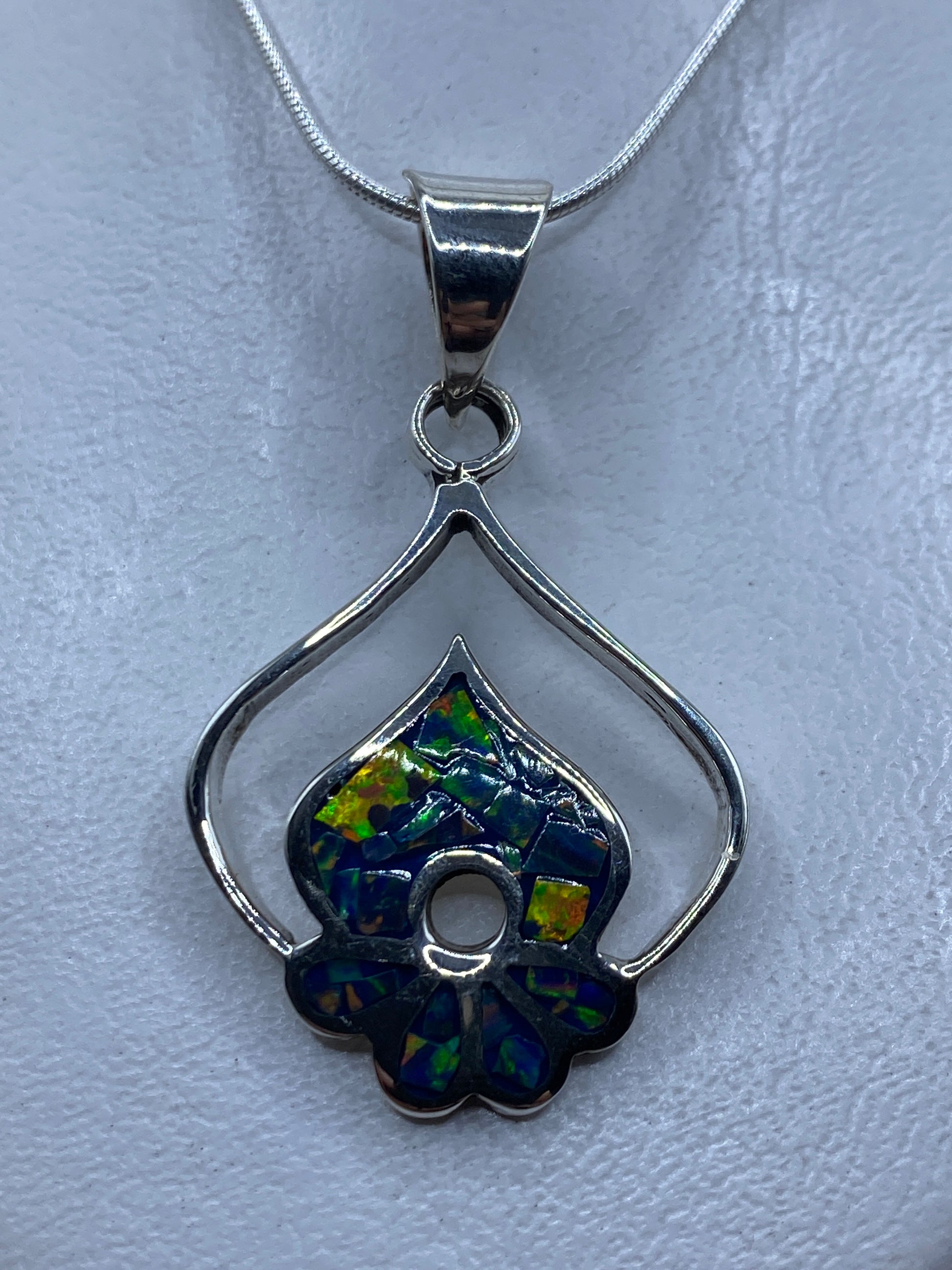 Dije de plata floral con ópalo de fuego natural, tonos verdes y azules, colgado en cadena