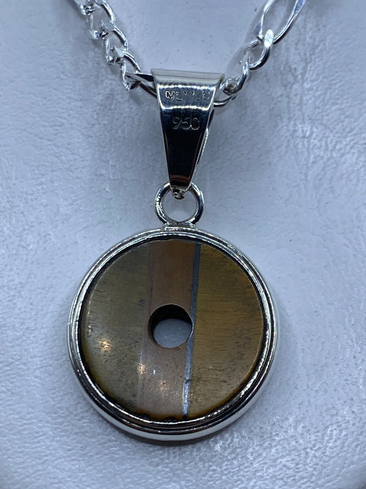 Dije redondo de plata .950 con piedra natural color café engastada, colgante sobre cadena de eslabones