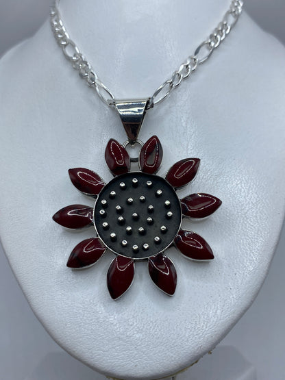 Dije girasol portado en collar de cadena figaro plateada