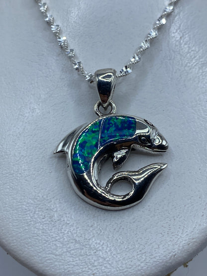Dije de plata con ópalo de fuego azul verdoso, mostrado con cadena de plata en el pecho