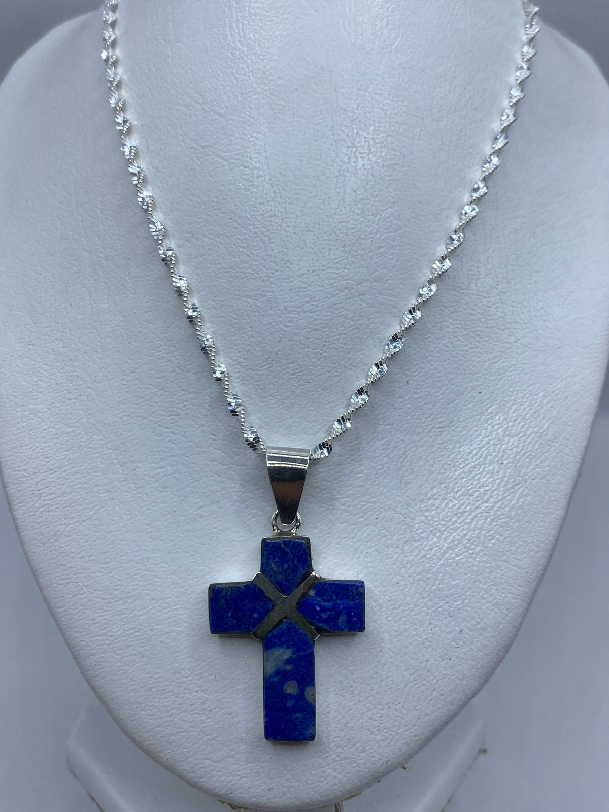 Dije cruz de 4.6 cm largo junto a regla de medición, mostrando tamaño real