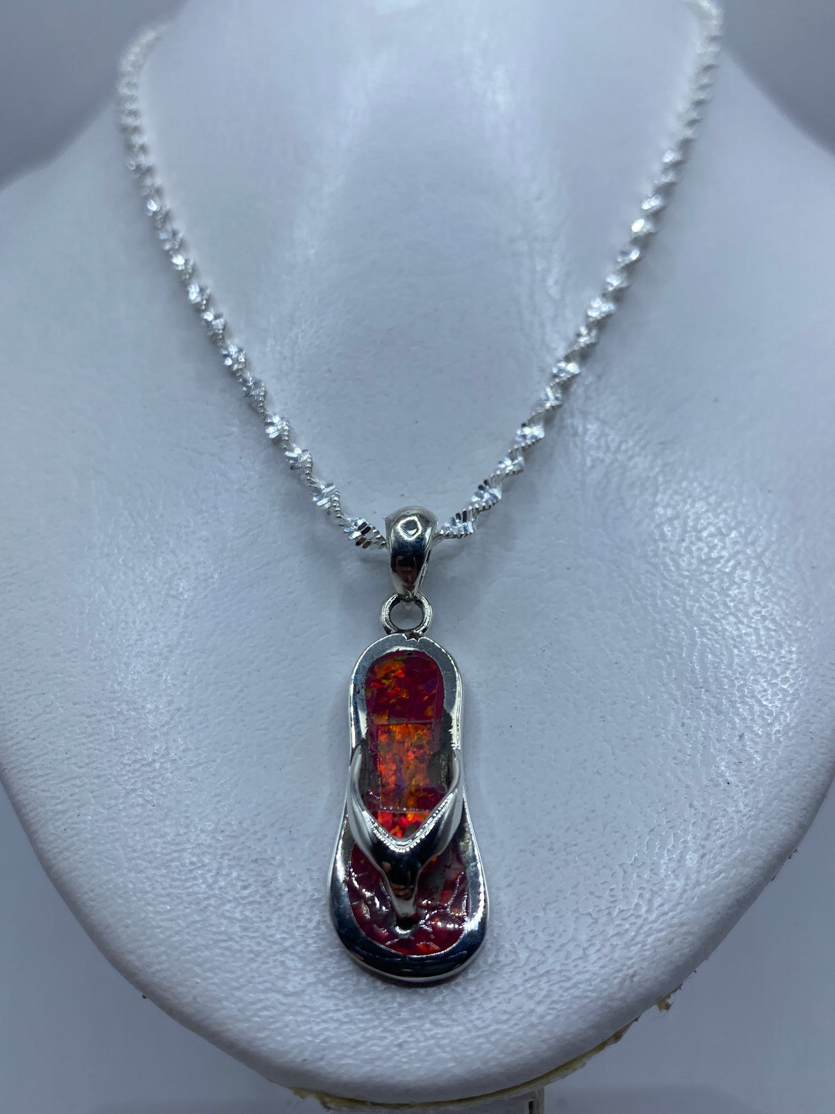 Detalle del ópalo de fuego rosa con reflejos de luz naranjas y rojos