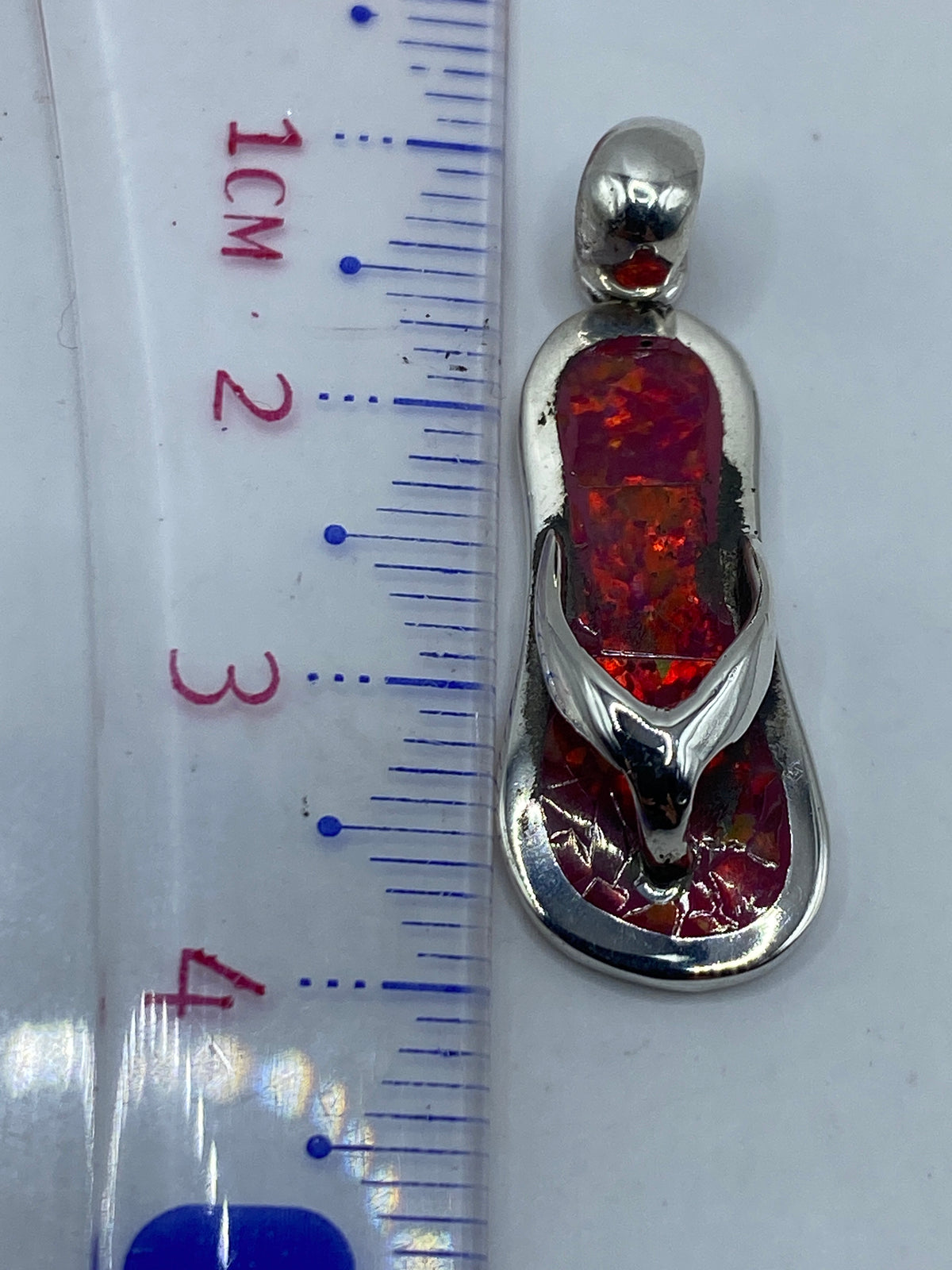Dije sobre regla midiendo 4.1 cm de largo, foto de referencia de tamaño