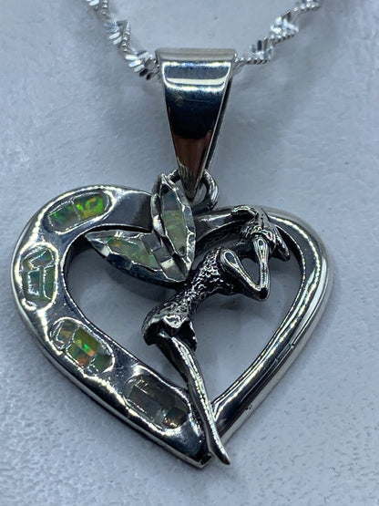 Dije de plata en forma de corazón con ópalo de fuego multicolor y serpiente enlazada
