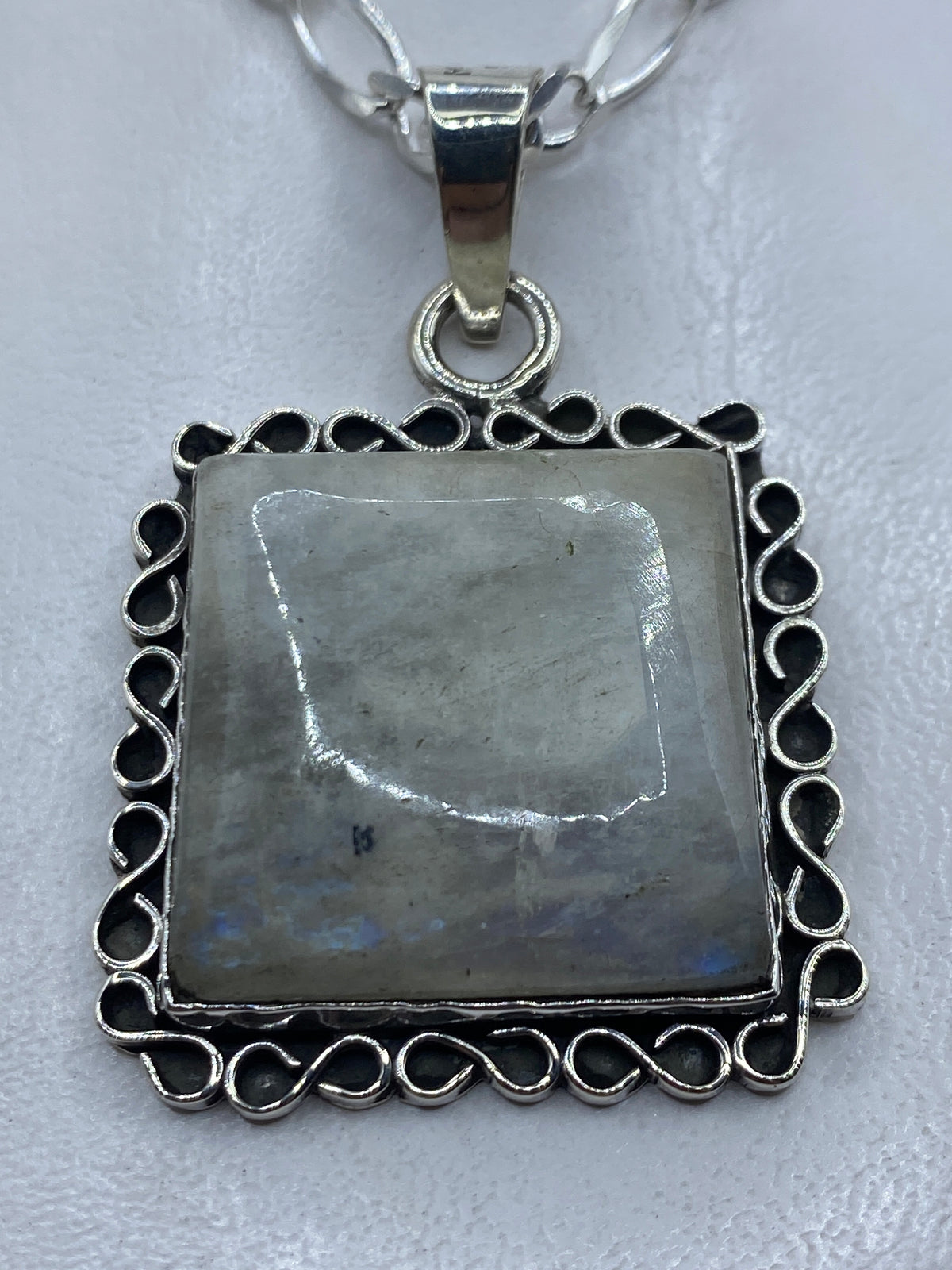 Dije cuadrado de plata .925 con piedra incrustada y marco de filigrana calada