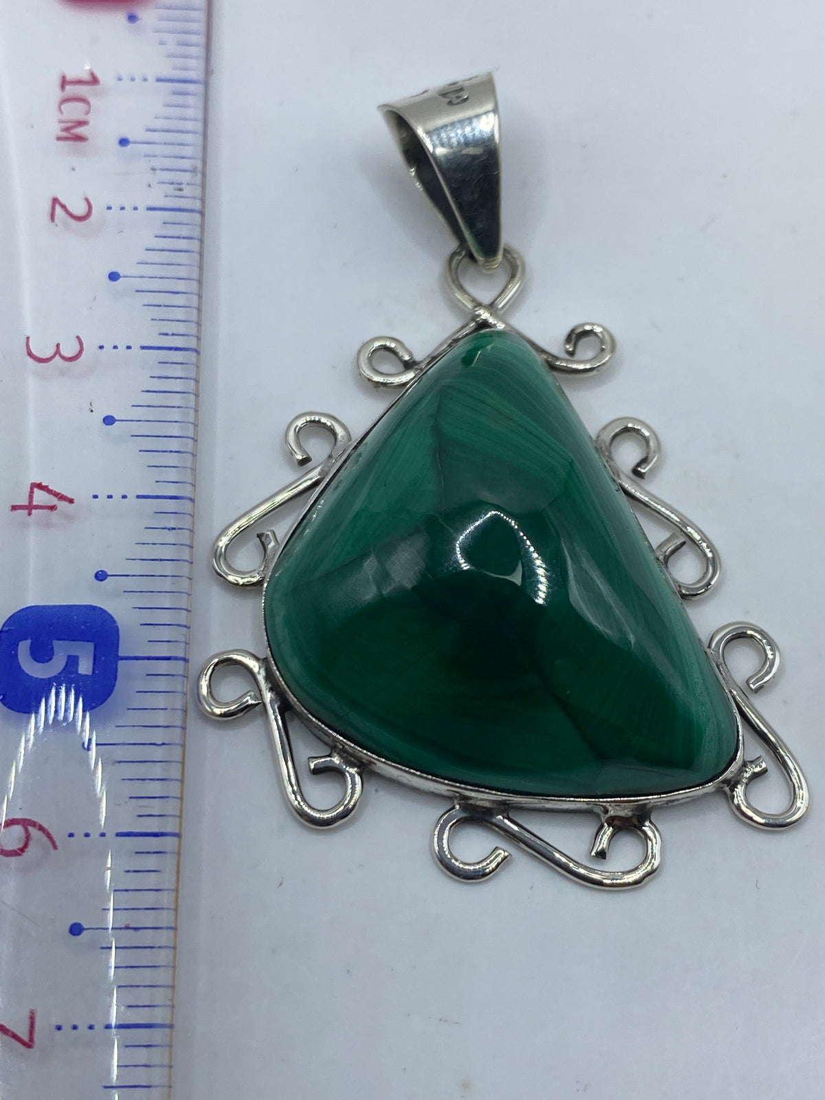 Dije sobre medidor: 6.1 cm de largo, 15.5 gramos