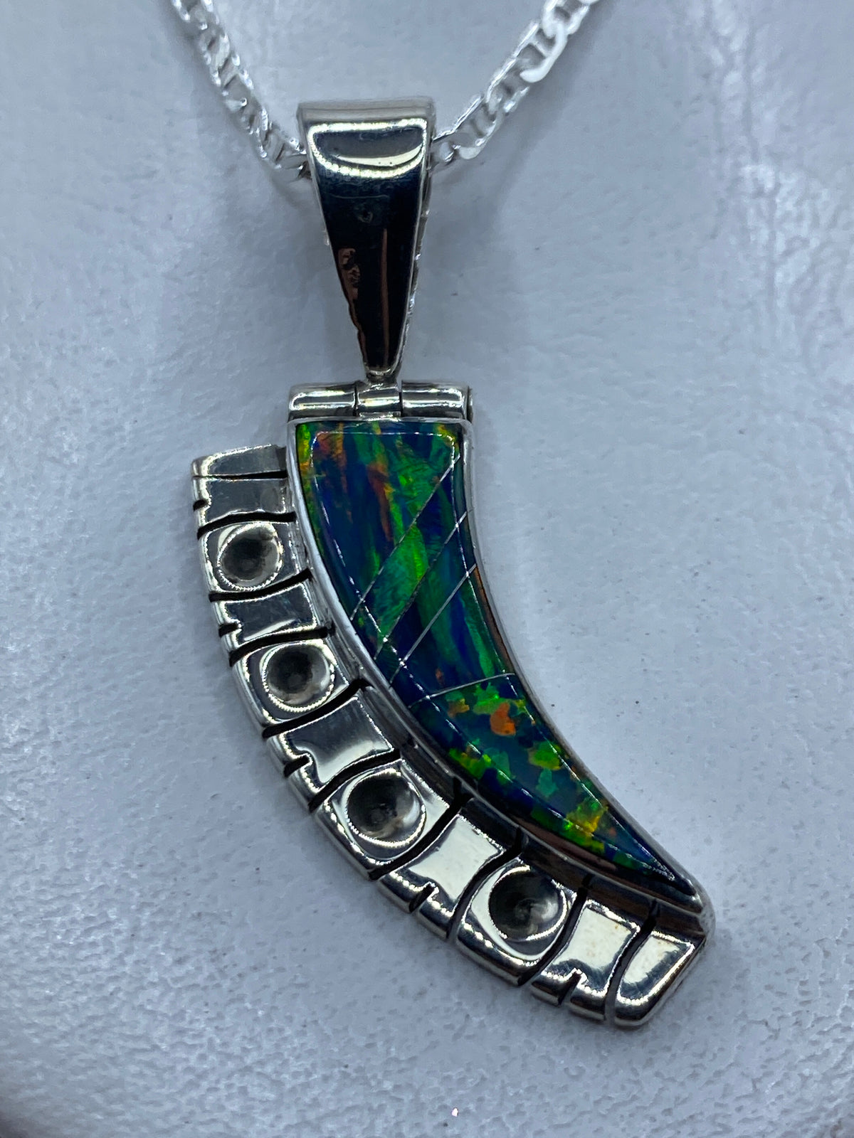 Dije de plata .950 con ópalo de fuego azul curvado, engastado a mano, colgando de una cadena plateada