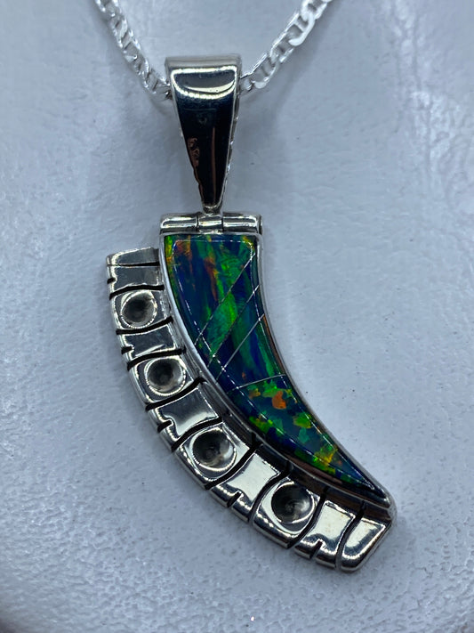 Dije de plata .950 con ópalo de fuego azul curvado, engastado a mano, colgando de una cadena plateada