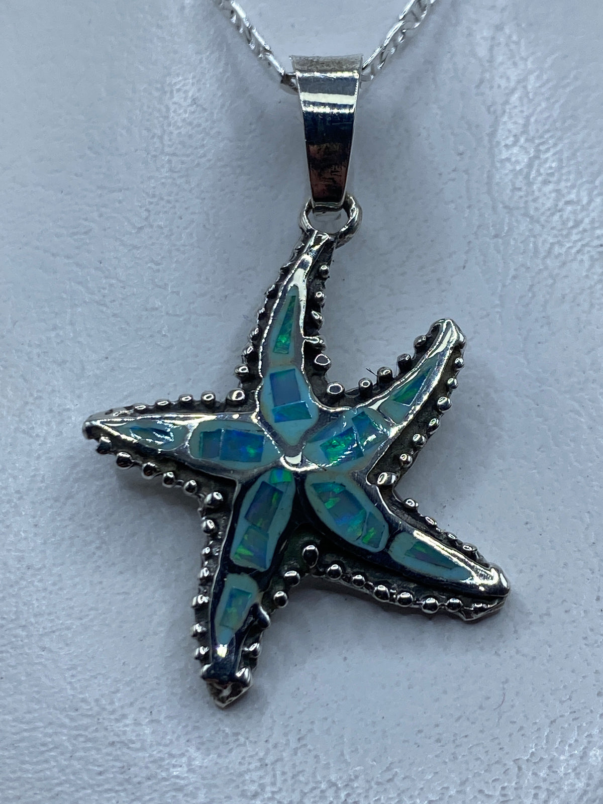 Dije de estrella marina en plata .925 con ópalo de fuego azul cielo, engastado a mano
