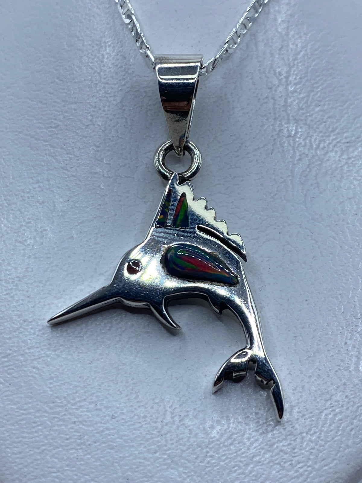 Dije de plata en forma de pez (marlín) con ópalo de fuego azul engastado, visto de frente