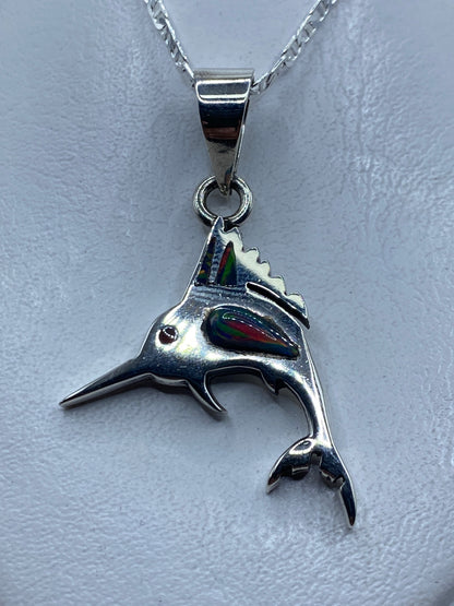Dije de plata en forma de pez (marlín) con ópalo de fuego azul engastado, visto de frente