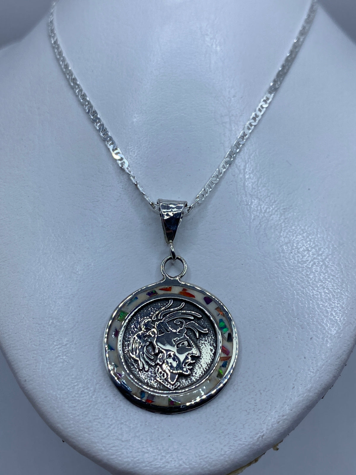 Detalle del motivo prehispánico tallado en plata de Taxco con piedra ópalo multicolor