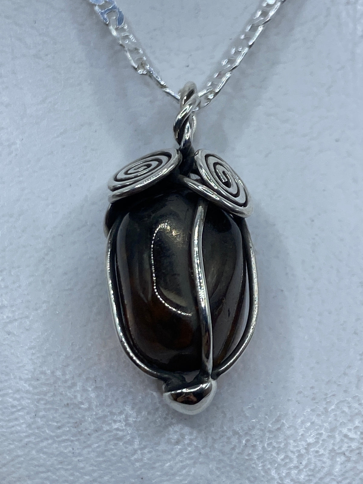 Dije de plata .925 con ámbar natural engastado, largo 3.6 cm, colgando de una cadena plateada