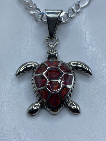 Dije de tortuga marina en plata .925 con ópalo de fuego rojo engastado a mano
