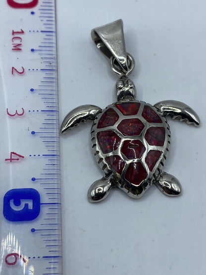 Dije tortuga de Taxco sobre fondo blanco mostrando las alas abiertas y el Quinto .925