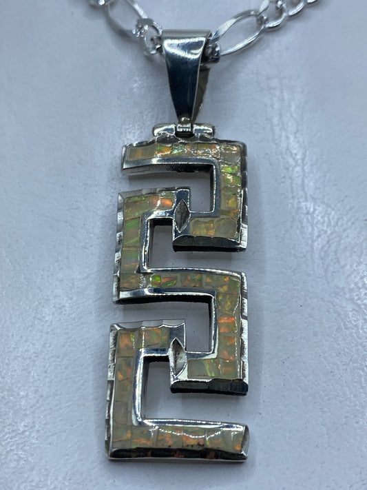 Dije de plata .950 con óptalo de fuego multicolor en diseño geométrico prehispánico, largo 6.2 cm
