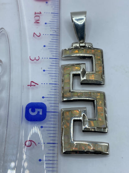 El dije colgando en el cuello, mostrando el tamaño real de 6.2 cm y cómo se ve puesto