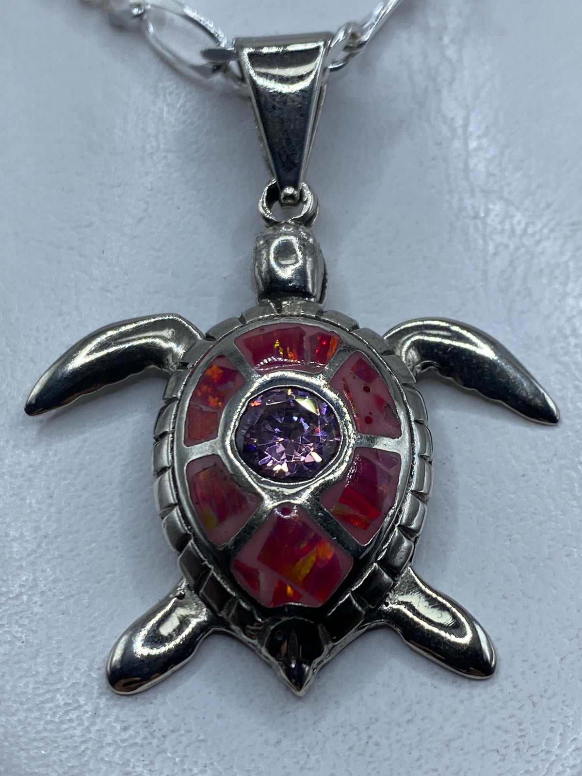 Dije tortuga de plata .950 con opalo de fuego rosa engastado, colgando de una cadena