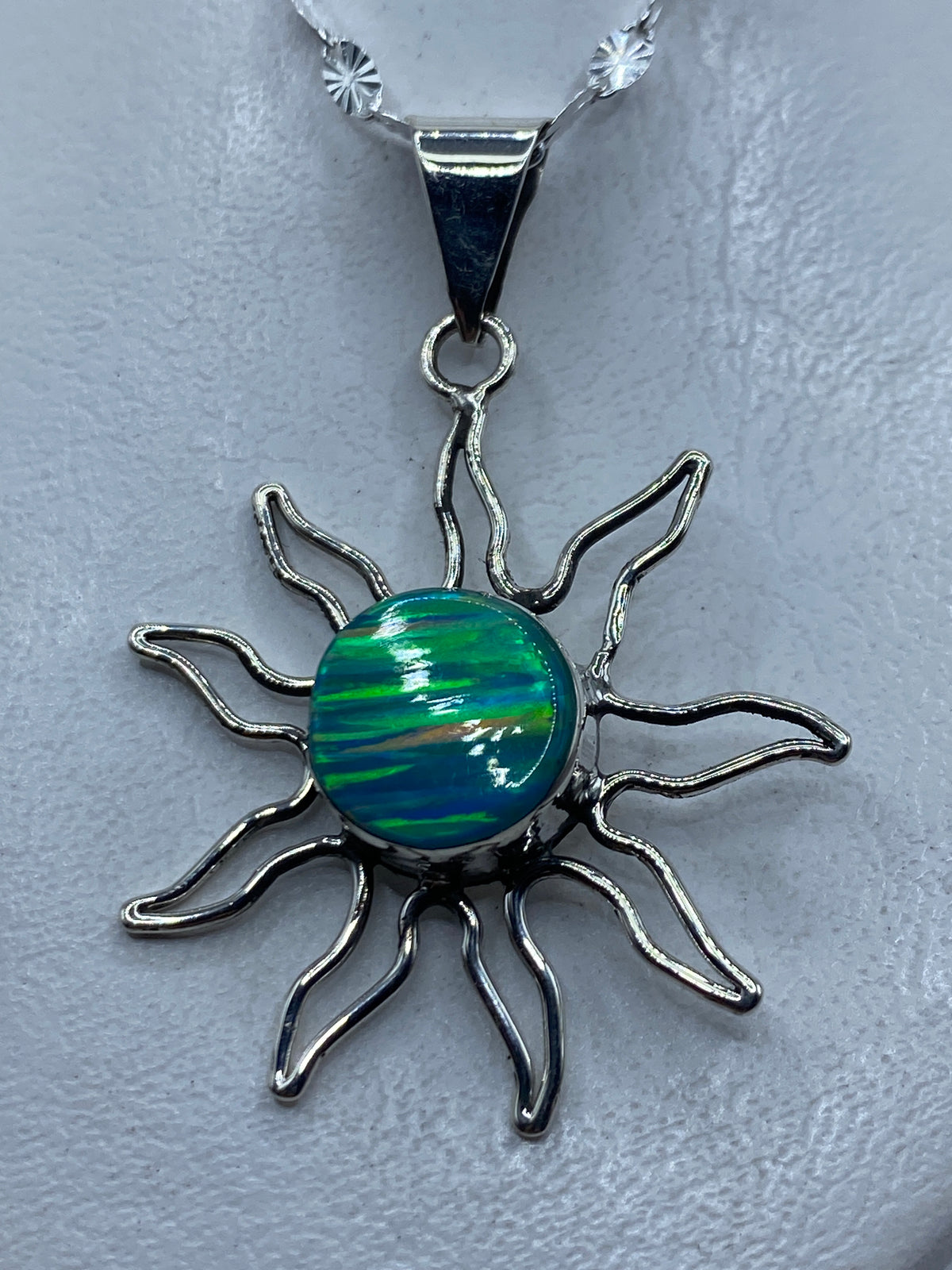 Dije sol de plata .950 con opalo de fuego azul cielo, radiante sobre piel