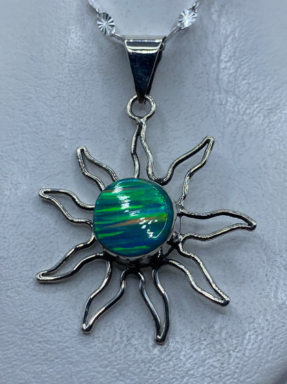 Dije sol de plata .950 con opalo de fuego azul cielo, radiante sobre piel