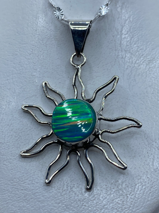 Dije sol de plata .950 con opalo de fuego azul cielo, radiante sobre piel