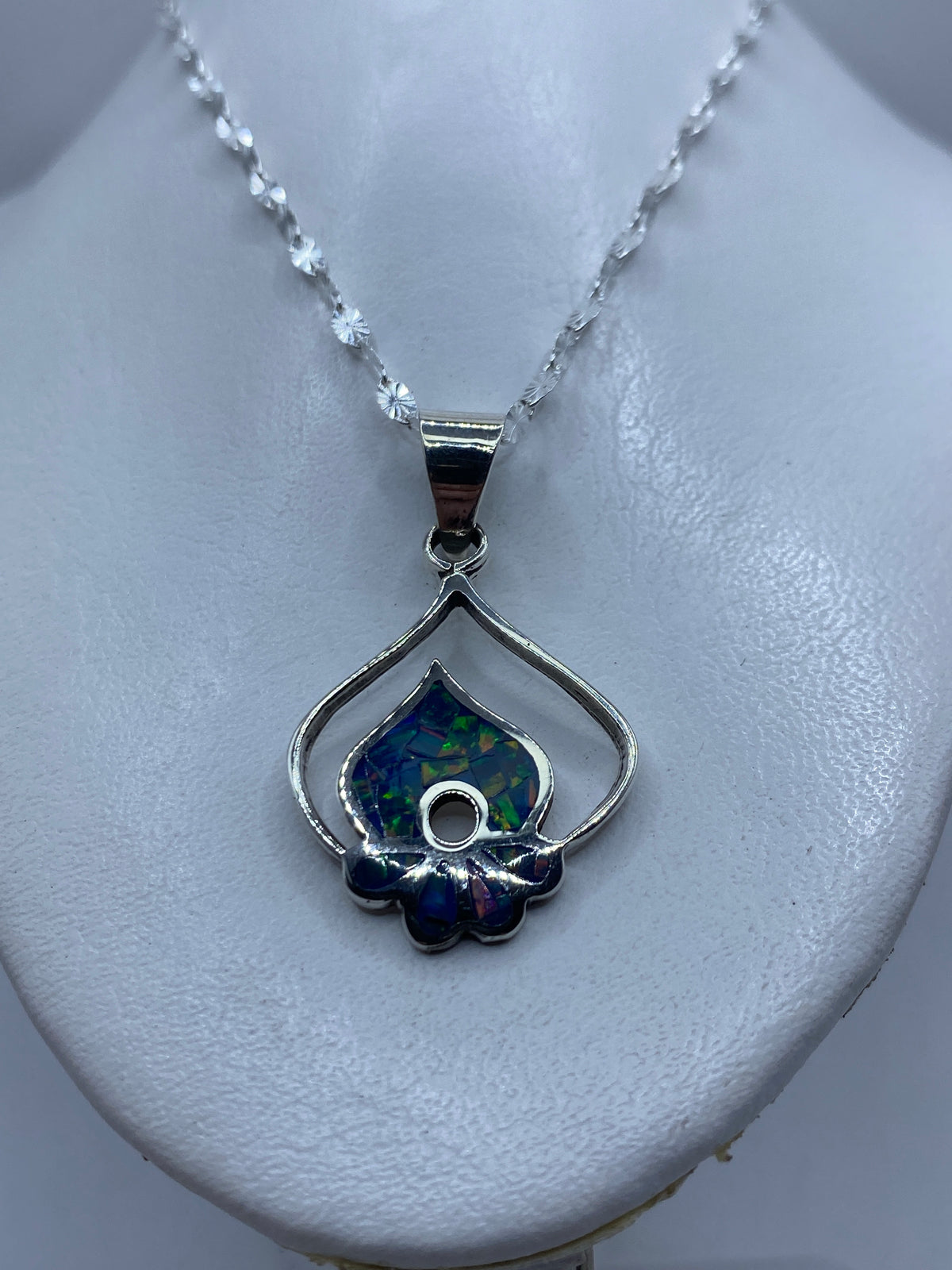 Dije de 4.5 cm de largo con ópalo azul brillante colgado en cadena de plata