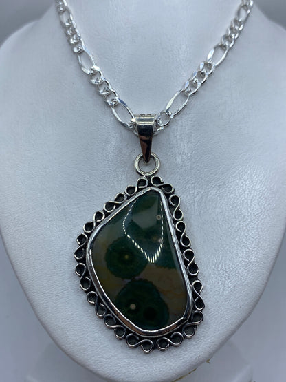 Dije pear de Taxco de 6.8 cm de largo con piedra verde olivo, sin cadena, visto sobre fondo blanco