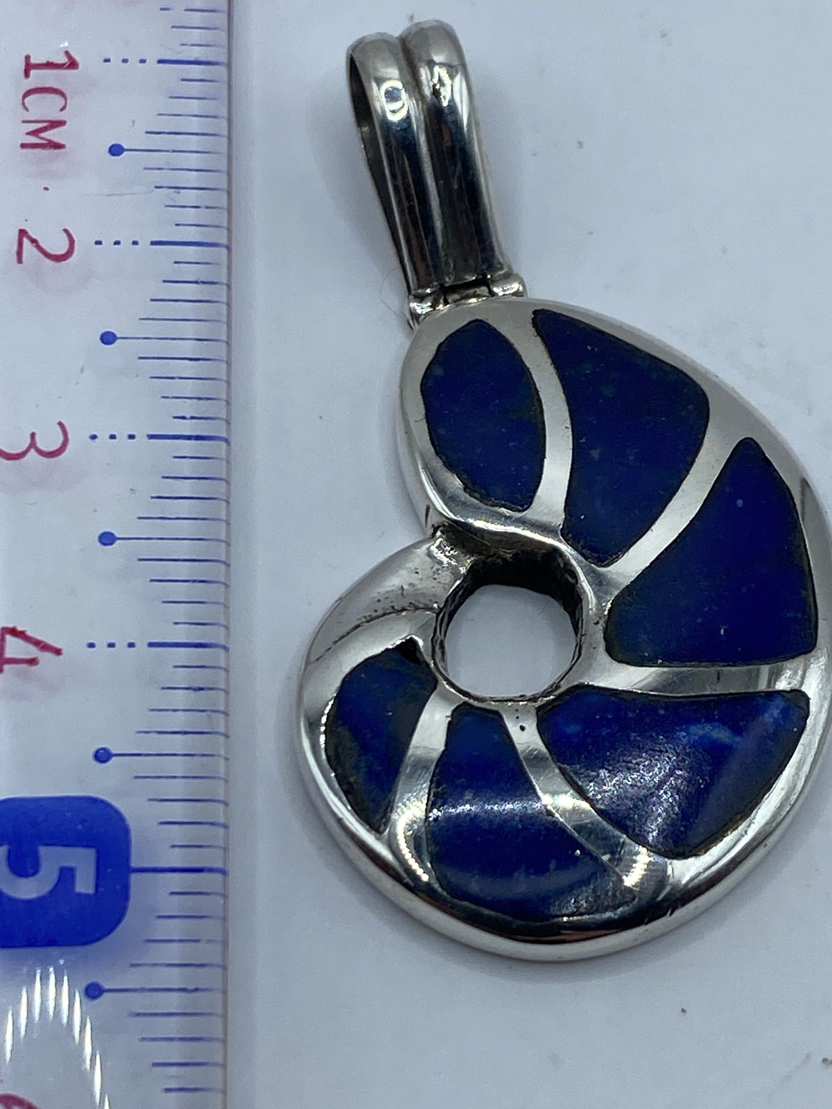 Dije combinado con otras joyas de plata en el pecho de una mujer