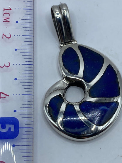 Dije combinado con otras joyas de plata en el pecho de una mujer