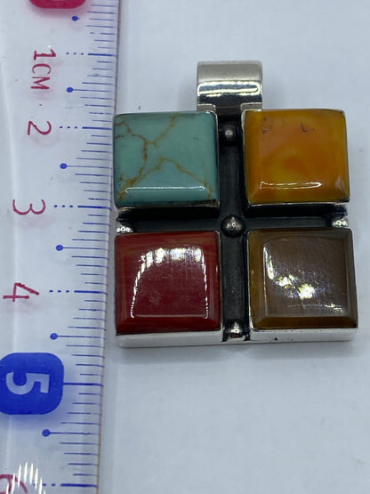 Dije sobre fondo blanco mostrando la argolla de plata para cadena