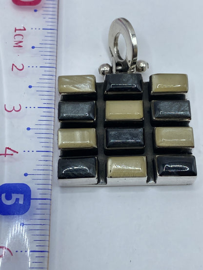 Dije sobre fondo blanco destacando el contraste de piedras incrustadas en plata